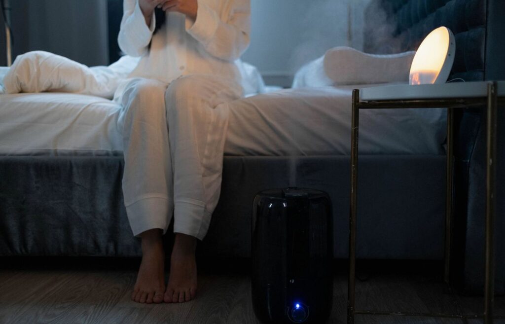 Nawilżacz powietrza z parą wodną na szafce nocnej w sypialni